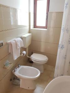 biała łazienka z toaletą i umywalką w obiekcie Hotel Residence Il Mulino w mieście Alicudi