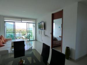 a living room with a couch and a table with chairs at Costa Azul Suites 906 in Santa Marta