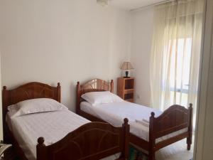 two twin beds in a bedroom with a window at Apartament Berati in Berat