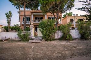 ein großes Haus mit Bäumen davor in der Unterkunft Villa marina " G " in Argassi