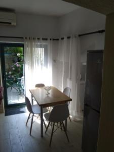 ein Esszimmer mit einem Tisch, Stühlen und einem Fenster in der Unterkunft Studio Apartman GRACIJA in Herceg-Novi