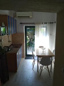 eine Küche und ein Esszimmer mit einem Tisch und Stühlen in der Unterkunft Studio Apartman GRACIJA in Herceg-Novi