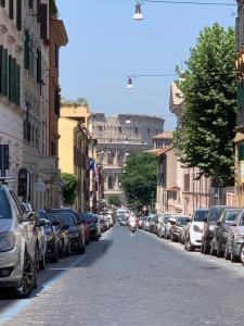 a street with parked cars and a motorcycle on a city street at Colosseo Boutique Apartment in Rome
