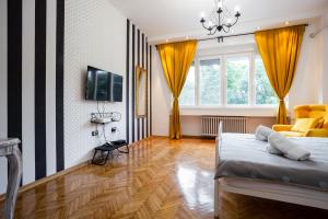a bedroom with a bed and a tv and a couch at Apartment Korzo in Novi Sad