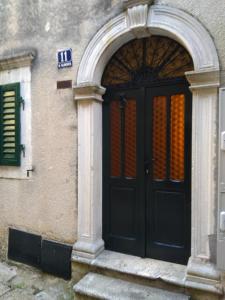 einen Eingang zu einem Gebäude mit einer schwarzen Tür in der Unterkunft Studio Apartman GRACIJA in Herceg-Novi