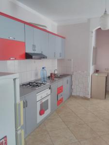 uma cozinha com armários brancos e um forno com placa de fogão em Queen Hostel em Durrës