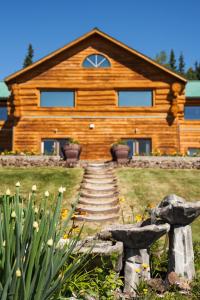 a log cabin with stairs in front of it at A Taste of Alaska Lodge in Fairbanks