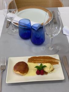 a plate of food on a table with wine glasses at Hostal Ezkaurre in Isaba