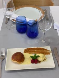 a plate of food on a table with wine glasses at Hostal Ezkaurre in Isaba