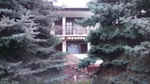 una casa con balcón en medio de dos árboles en Fenyő Windsurf vendégház, en Révfülöp