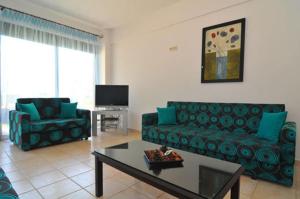 a living room with a couch and a table at Golden Sunrise Apartments in Chrysi Ammoudia