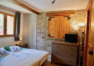 een slaapkamer met een bed en een tv op een dressoir bij Chalet avec jardin proche piste in Les Deux Alpes