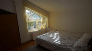 a small bedroom with a bed and a window at Nicolae Romanescu Park in Craiova