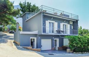 a blue house with a balcony on a street at VILLA BEST in Bast