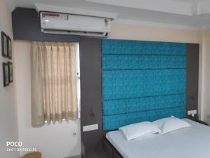 a bedroom with a blue headboard and a bed at Saraswati Retreat in Bhubaneshwar