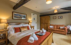 a bedroom with a large bed and a couch at Kirkstile Inn in Loweswater