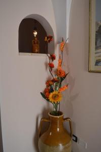 een vaas met bloemen naast een muur bij Casa del Bicio in Ceglie Messapica