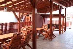 een patio met houten tafels en stoelen in een gebouw bij Penzion - Peri in Hokovce