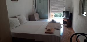 una camera da letto con un letto e un asciugamano sopra di Apartmani Neda Bane a Petrovac na Moru