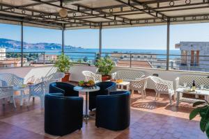 un restaurante con mesas y sillas y vistas al océano en ApartHotel Stijovic, en Bar