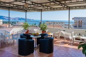 a restaurant with tables and chairs and a view of the ocean at ApartHotel Stijovic in Bar