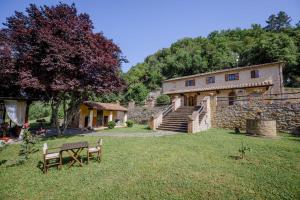 une maison en pierre avec un banc dans la cour dans l'établissement Villa Loghino, à Volterra