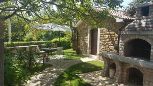 a patio with a table and an outdoor fireplace at Studio apartment Cami - Cottage with a soul in Gračišće