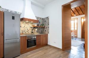 une cuisine avec un réfrigérateur en acier inoxydable et des armoires en bois dans l'établissement La Casita de Juana, à Buenavista del Norte