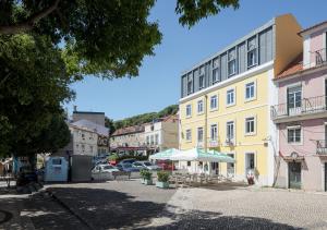 Eine Straße in einer Stadt mit einem gelben Gebäude in der Unterkunft Studio Hideaway- in a Traditional Neighborhood in Lissabon
