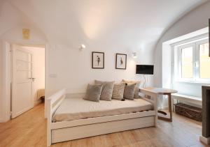 ein weißes Bett in einem Zimmer mit Fenster in der Unterkunft Studio Hideaway- in a Traditional Neighborhood in Lissabon