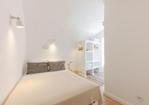 ein Schlafzimmer mit einem Bett in einem weißen Zimmer in der Unterkunft Studio Hideaway- in a Traditional Neighborhood in Lissabon