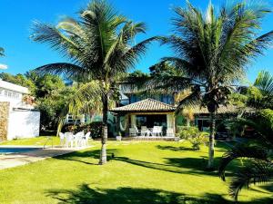 una casa con 2 palmeras y una piscina en Excelente casa a 150 mts da Praia da Ferradura, en Búzios