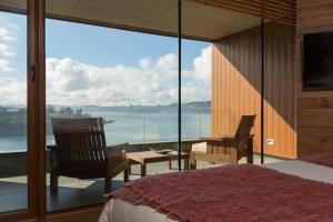a bedroom with a bed and a view of the water at Enjoy Chiloé in Castro
