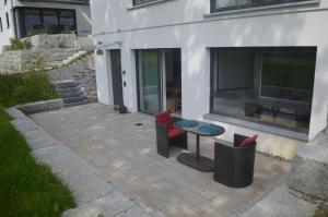 eine Terrasse mit 2 Stühlen und einem Tisch vor einem Gebäude in der Unterkunft Ferienwohnung "Am Kurpark" in Bad Schussenried in Bad Schussenried