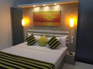 a bedroom with a bed with yellow and black pillows at Villa Dominikku in Negombo