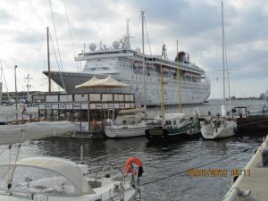 ein Kreuzfahrtschiff, das an einem Dock mit Booten angedockt ist in der Unterkunft Altstadt Ferienwohnung in Wismar