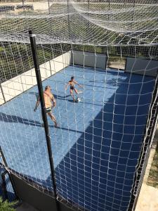 deux hommes jouant avec un ballon de football dans un but dans l'établissement Holiday House Vita, à Klis