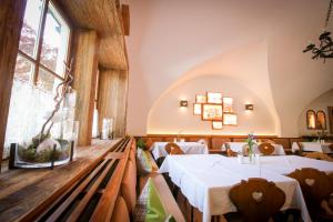 un restaurante con mesas y sillas blancas y ventanas en Gasthof Post, en Rennweg