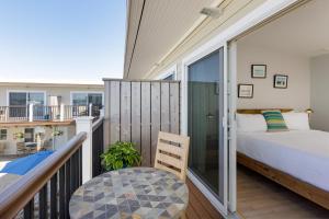 a bedroom with a bed and a balcony at Aqualina Inn Montauk in Montauk