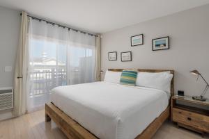 Un dormitorio con una cama grande y una ventana en Aqualina Inn Montauk en Montauk