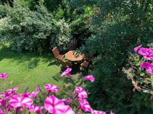 a table and chairs in a garden with pink flowers at Landhaus Haack in Tümlauer Koog