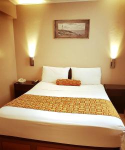 een bed in een hotelkamer met 2 verlichting bij Hostal Lince in Lima