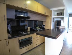 a kitchen with a black counter top and wooden cabinets at Metroloft 204 in Armenia