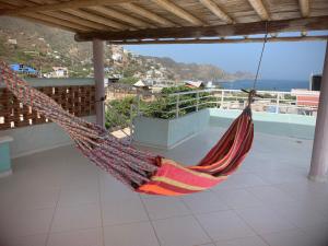 een hangmat op een balkon met uitzicht op de oceaan bij Casa Bella Mya in Taganga
