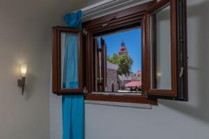 une fenêtre avec vue sur un bâtiment dans l'établissement BIBLIOTHEQUE, à Rhodes