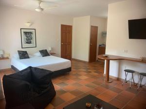 a bedroom with a bed and a table and a desk at Casa Bella Mya in Taganga