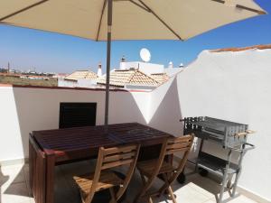 un tavolo e sedie con un ombrellone in un patio di Casa do canto a Tavira