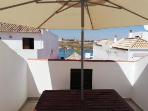 un tavolo con ombrellone su un balcone di Casa do canto a Tavira