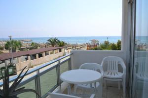 d'un balcon avec une table et des chaises et une vue sur l'océan. dans l'établissement 13 Sandy Beach Mackenzie, à Larnaka