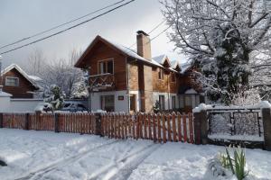 a house with a fence in the snow at Cabañas Quilquihue in San Martín de los Andes